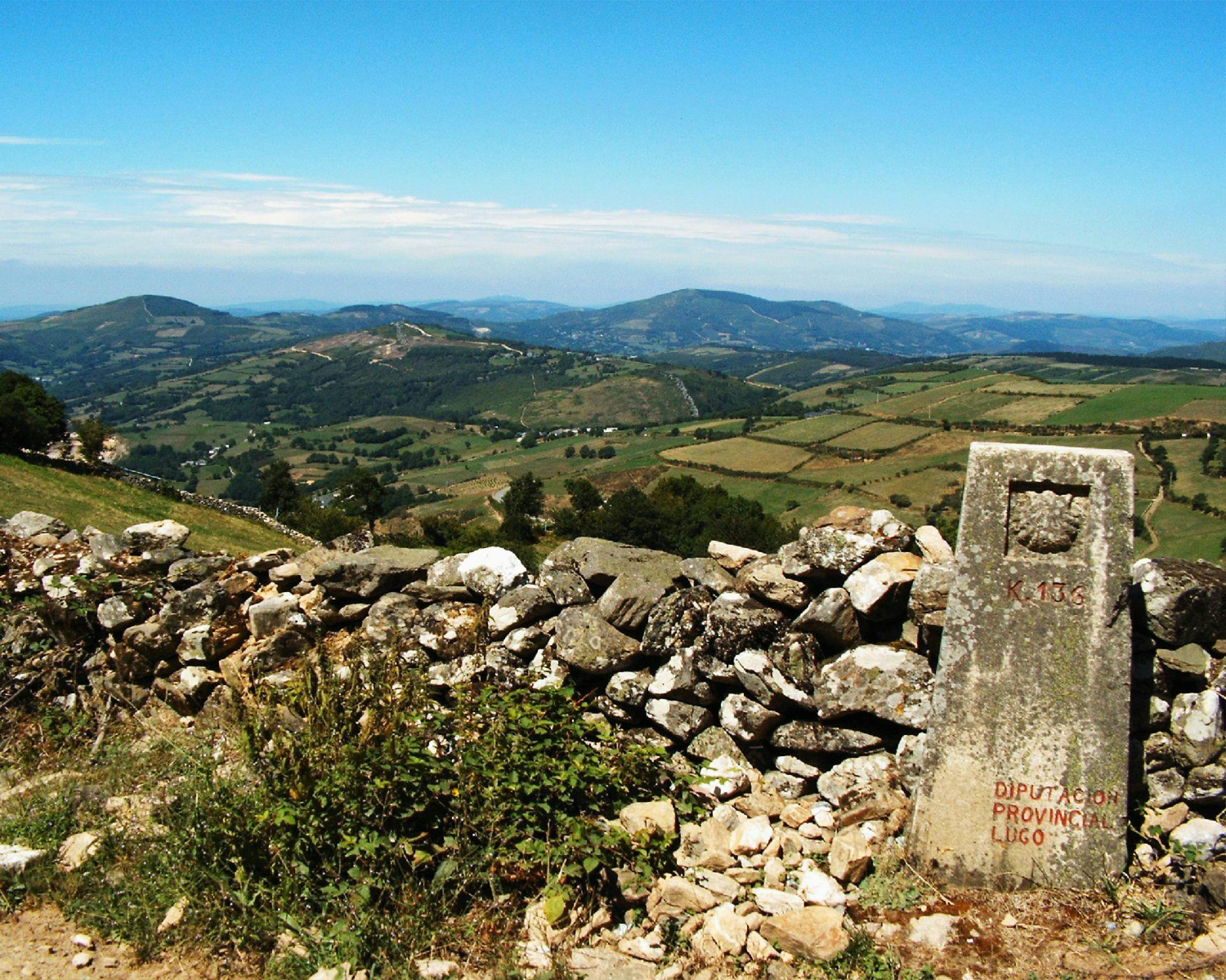 Camino de Santiago stone signal and the fields of Triacastela.
