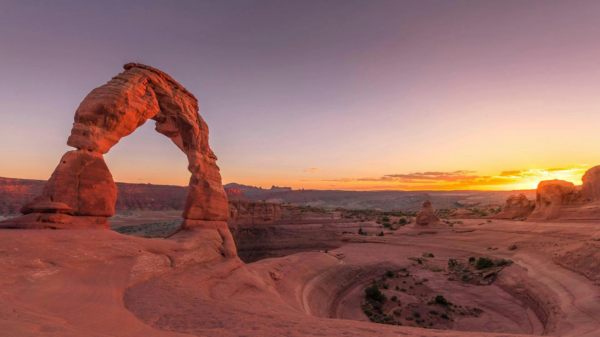 The Delicate Arch with a sunset in the background at Arches National Park.