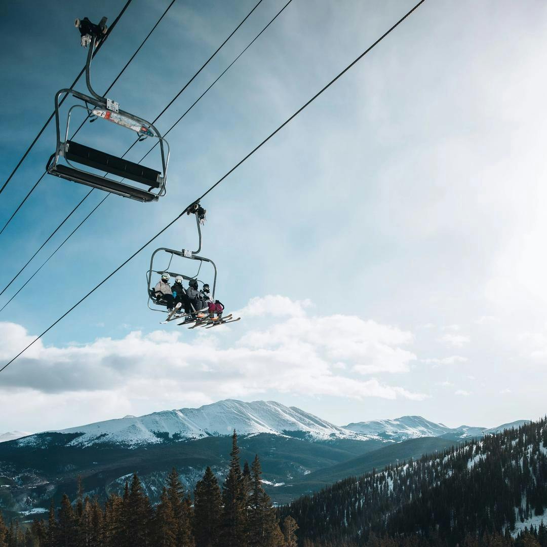 A group of skiers riding a chair lift at Breckenridge ski resort.
